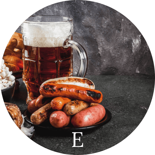 Beer and Sausages on a black table representing European Cuisine
